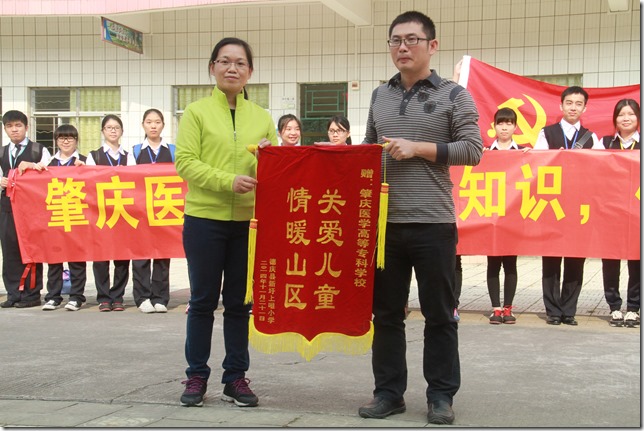 上咀小学校长王建瑜（右) 赠送锦旗